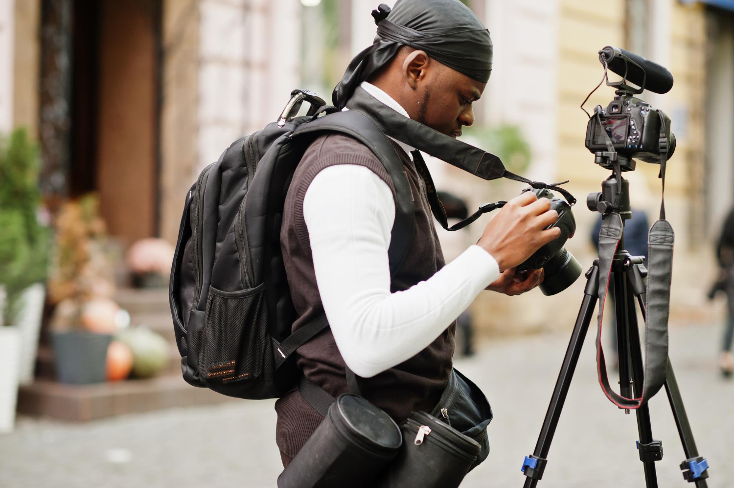 young-professional-african-american-videographer-holding-professional-camera-with-tripod-pro-equipment-afro-cameraman-wearing-black-duraq-making-videos